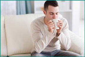 Muškarac pije čaj s mentom, želeći izliječiti erektilnu disfunkciju. 